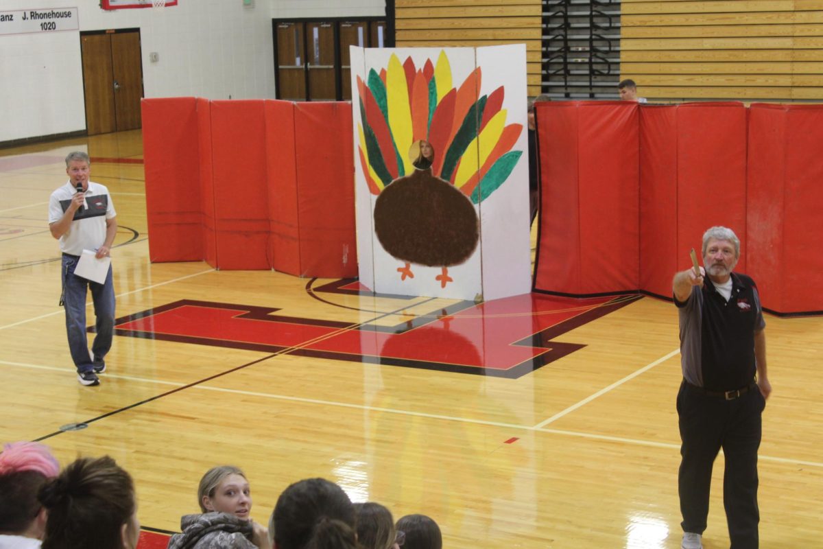 Mr. Wirick and Mr. Camp run the auction as a student council turkey waits to see how much they bring.